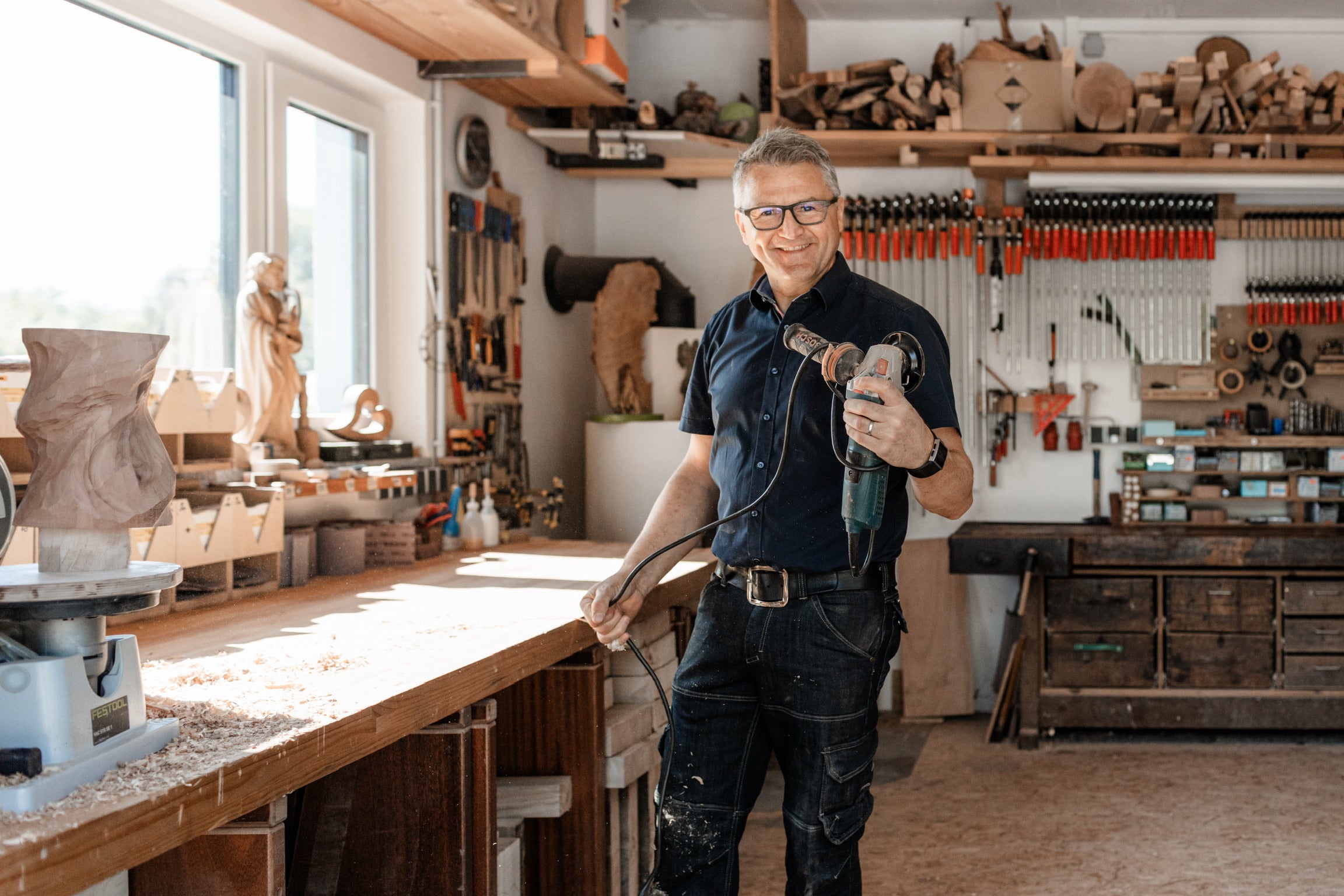 Martin Mayer hält eine kleine Fräse in seiner Werkstatt